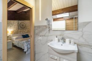 ein Badezimmer mit Waschbecken und Bett in der Unterkunft Le Saline Rooms Marzamemi in Marzamemi + 185 Fotos
