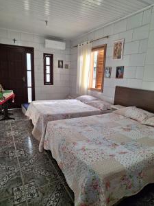 a room with four beds in a room at Habitación Familiar in Pântano Grande +2 photos
