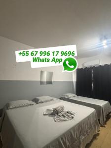 two beds sitting next to each other in a room at Hotel Centro in Corumbá