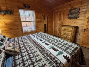 a bedroom with a bed in a log cabin at Hillside Hideaway Cabin in Blairsville