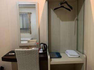 een badkamer met een spiegel en een wastafelmeubel met twee stoelen bij Grand Bydiel in Lanjang