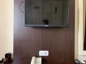 een flatscreen-tv die aan de muur hangt bij Grand Bydiel in Lanjang