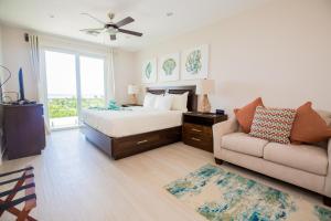 una camera da letto con un letto, un divano e una finestra di Sunset Caribe Belize a San Pedro Altre 62 foto