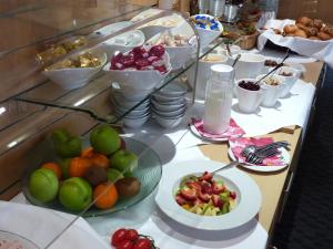 a buffet with plates of fruit on a table at Hasi's Hotel in Grafing