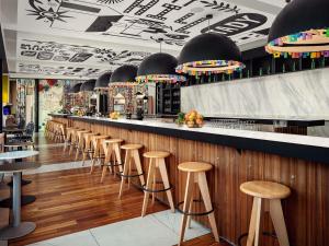 eine Bar mit einer Reihe von Hockern in einem Restaurant in der Unterkunft Mama Shelter Prague in Prag