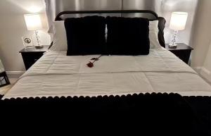 ein schwarz-weißes Bett mit zwei Lampen und einer roten Rose darauf in der Unterkunft Hotness in Chandernagore Settlement