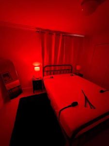 ein rotes Schlafzimmer mit einem Bett mit rotem Licht in der Unterkunft Hotness in Chandernagore Settlement