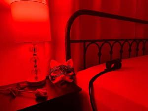 ein rotes Schlafzimmer mit einem Bett, auf dem eine Maske liegt in der Unterkunft Hotness in Chandernagore Settlement