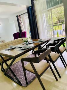 een eettafel en stoelen in de woonkamer bij Grey Nest Grey point 303 in Kericho