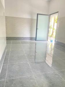 an empty room with a tile floor and a glass door at Home Vuon Dua in Ấp Nhứt (1)
