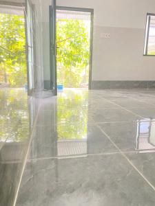 an empty room with a glass door and a chair at Home Vuon Dua in Ấp Nhứt (1)