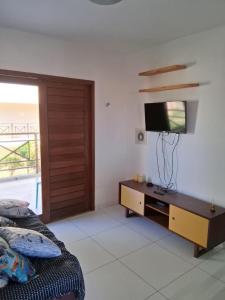 a bedroom with a bed and a flat screen tv at Apartamentos e Casas em Barra do Cunhaú in Canguaretama