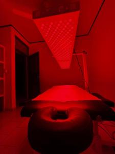 een rode kamer met een bed en een rood licht bij Casa Ocho in Jacó +2 foto's