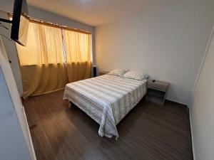 a small bedroom with a bed and a window at Mn Depa en San Bartolo in San Bartolo