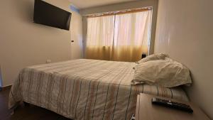 una camera con letto e finestra con tastiera di Mn Depa en San Bartolo a San Bartolo