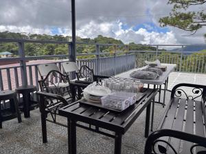 a table and chairs on a balcony with a view of the ocean at Nica's Palace Baguio in Baguio