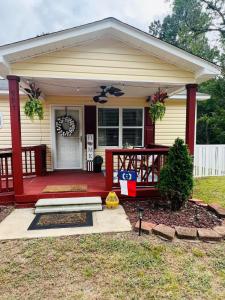 une maison avec un porche rouge et une pancarte dessus dans l'établissement Tree Farm Stay Fire Pit & Grill WOW-King Suite, à Fayetteville