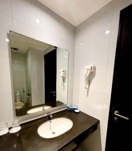 een badkamer met een wastafel en een spiegel bij Hotel Brothers Solo in Solo +3 foto's