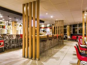 a restaurant with a bar with stools at ibis Marilia in Marília