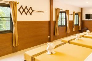 a room with two beds with towel animals on them at ภูน้ำทิพย์ รีสอร์ท in Ban Huai Phai