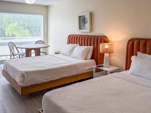 una camera d'albergo con due letti e un tavolo di Ocean Lodge a Boca Raton