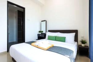 a bedroom with a large white bed with green accents at NOVO 8 Residence Melaka in Malacca