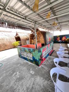 een kamer met tafels en witte stoelen erin bij The Twins Sunset Bungalow in Palebah +11 foto's