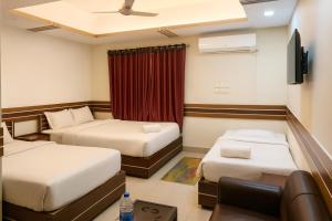 a hotel room with two beds and a couch at Baral Richmart Resthouse in Barisāl