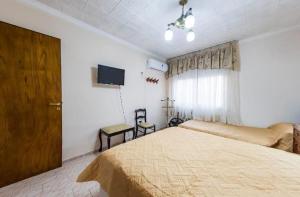 ein Schlafzimmer mit großem Bett und Flachbildfernseher in der Unterkunft Hosteria TDT in Mar del Plata