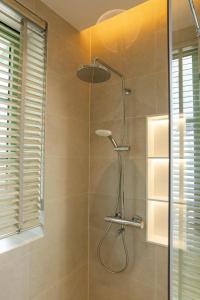 une douche avec pommeau de douche dans une salle de bain dans l'établissement Green Villas Tropical Phú Quốc, à Duong Dong