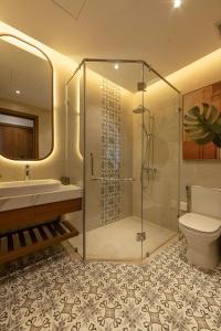 une salle de bains avec douche, lavabo et toilettes dans l'établissement Green Villas Tropical Phú Quốc, à Duong Dong