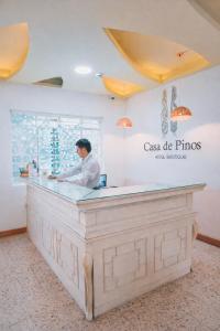 a man standing at a counter in a restaurant at Casa de Pinos Hotel Boutique in Bucaramanga