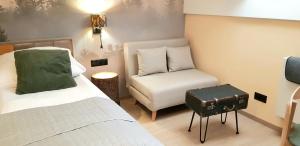 una camera da letto con un letto e una sedia con una valigia di Apartament Ricardo a Krynica-Zdrój