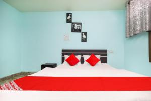 een slaapkamer met een groot bed met rode kussens bij Super Hotel O A Hotel in Dhanbad