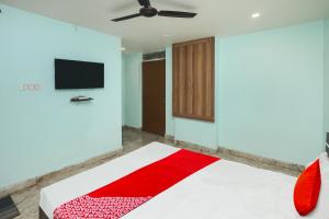 een kamer met een bed en een flatscreen-tv bij Super Hotel O A Hotel in Dhanbad