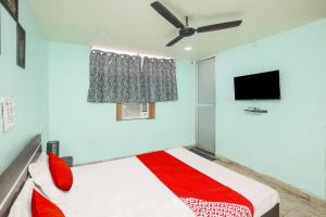 een slaapkamer met een bed en een plafondventilator bij Super Hotel O A Hotel in Dhanbad +21 foto's