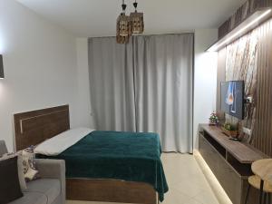 ein Schlafzimmer mit einem Bett, einem Fernseher und einer Couch in der Unterkunft Florenza khamsin aprt F7 in Hurghada