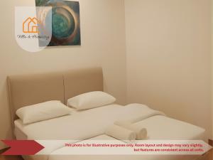 een bed met twee kussens in een kamer met een schilderij bij Elevé Gamuda in Banting