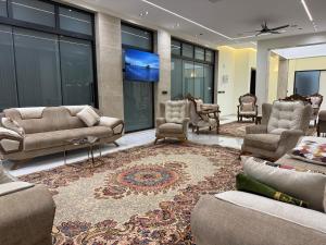 a living room with couches and chairs on a rug at مزرعة منتجع الامراء in Baghdād