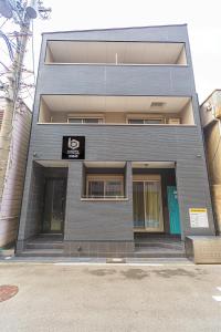 a gray building with a sign on the front of it at b&岸里店 in Osaka