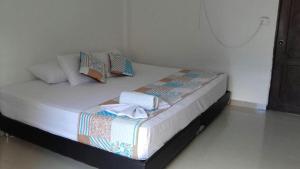 een bed in een kamer met kussens erop bij Hotel Plazuela Real in Barrancabermeja
