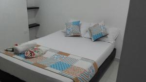 een bed met kussens en een dekbed erop bij Hotel Plazuela Real in Barrancabermeja
