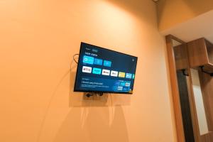un téléviseur à écran plat accroché au mur dans l'établissement Grand Damai Kostel Exclusive, à Ngaglik 18 autres photos