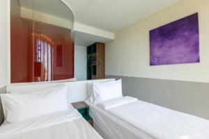 twee bedden in een kamer met een spiegel bij Wink Danang Centre, Unscripted by Hyatt in Da Nang +66 foto's