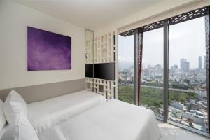 een slaapkamer met witte meubels en grote ramen bij Wink Danang Riverside, Unscripted by Hyatt in Da Nang
