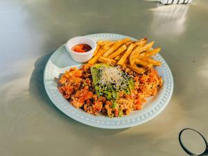 un piatto di cibo con broccoli, patatine fritte e salsa di Viajero Oaxaca Hostel a Città di Oaxaca