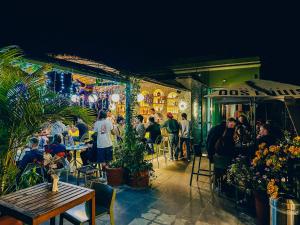 a group of people sitting at tables outside a restaurant at Viajero Oaxaca Hostel in Oaxaca City