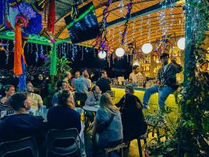 a group of people sitting at tables in a restaurant at Viajero Oaxaca Hostel in Oaxaca City