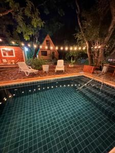 a swimming pool at night with a house at Helena Suites Alpina in Villarrica