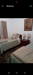 a bedroom with two beds and two lamps on tables at Casa Castillo 2 in La Puente